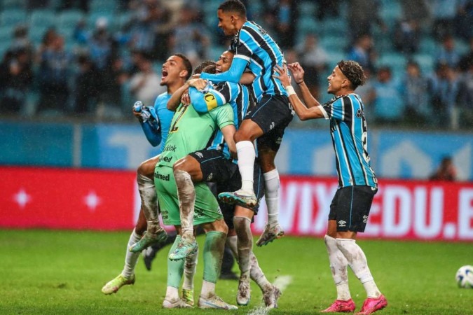 Grêmio corre para abraçar Gabriel Grando, um dos heróis da noite na Arena, em Porto Alegre -  (crédito: Lucas Uebel/Grêmio FBPA)